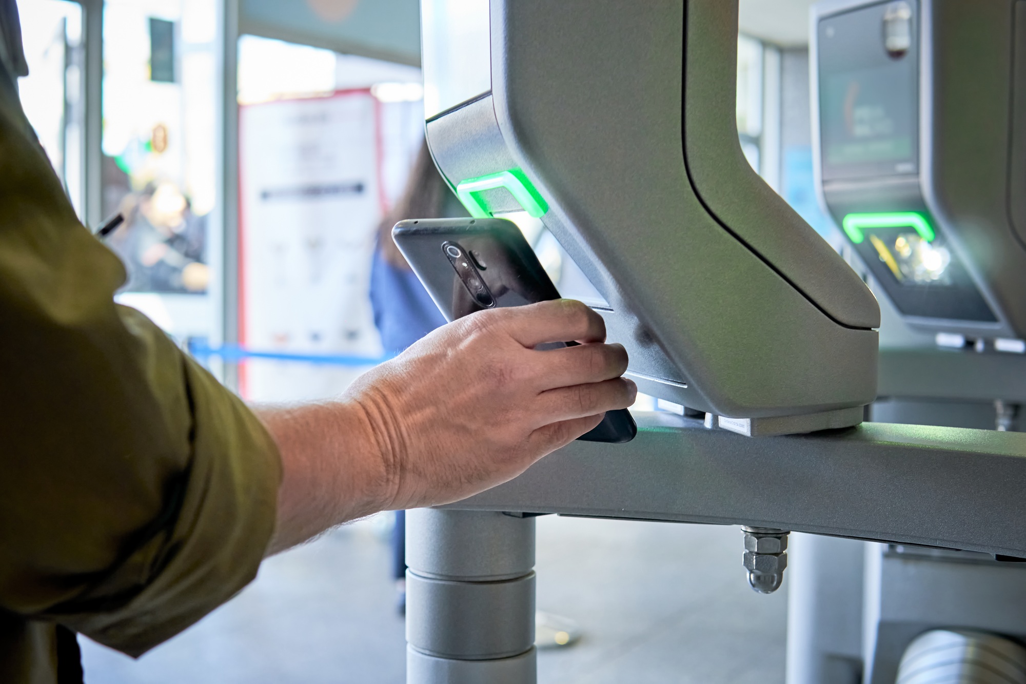 person scanning smartphone on a security control pass machine to entrer in a secured area